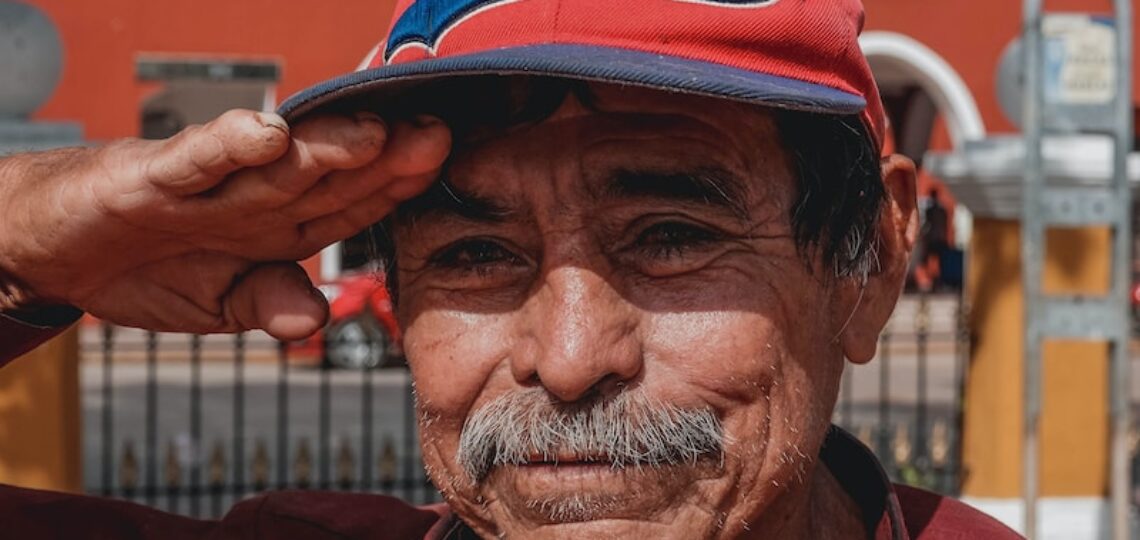 man in red button up shirt wearing black and red fitted cap