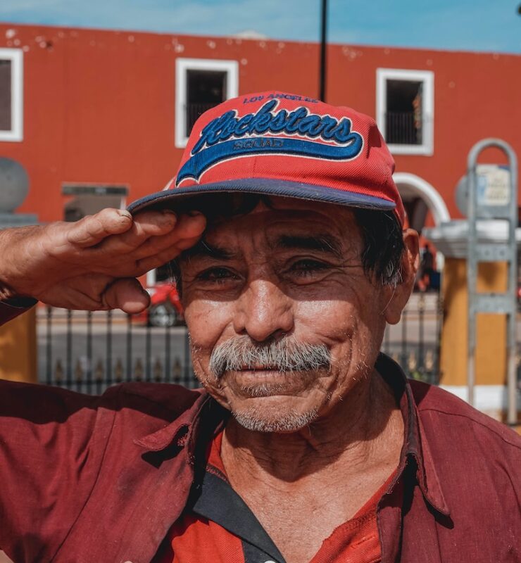 man in red button up shirt wearing black and red fitted cap